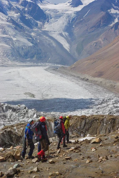 Viajeros senderismo en las montañas nevadas, Federación Rusa, Cáucaso, julio 2012 - foto de stock