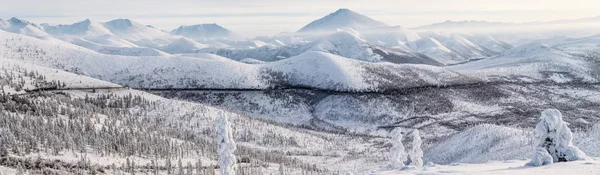 Belle route hivernale enneigée et arbres dans les montagnes enneigées, autoroute kolyma, fédération russe — Photo de stock