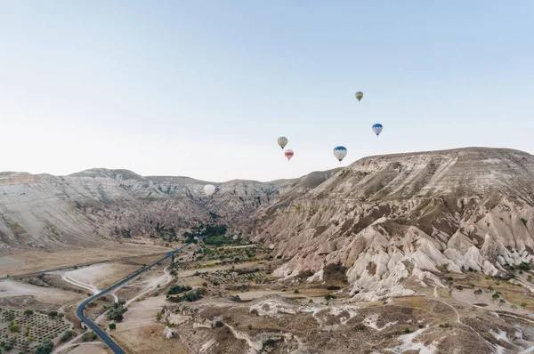 Paisagem montanhosa com balões de ar quente, Capadócia, Turquia — Fotografia de Stock