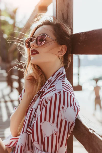 Close-up portrait of sensual young woman leaning back on pier at beach — Stock Photo