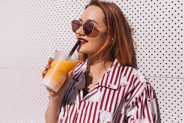 Lächelnde junge Frau trinkt Cocktail aus Plastikbecher — Stockfoto