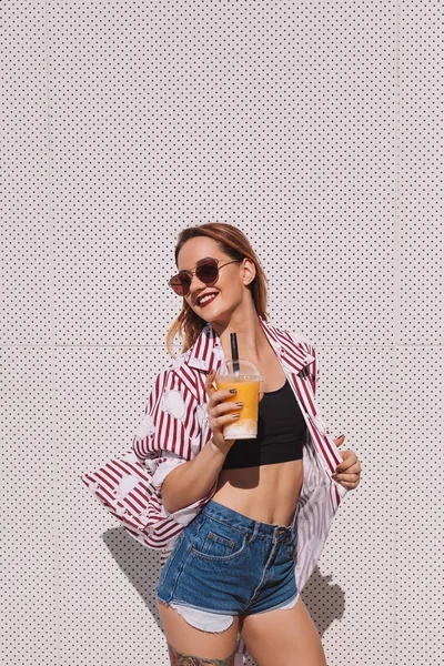 Stylish young woman with mango shake in plastic cup — Stock Photo