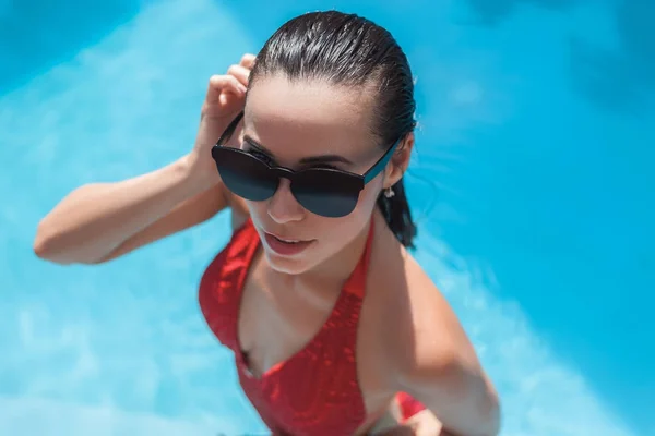 Vista de alto ângulo da jovem mulher molhada em maiô na piscina — Fotografia de Stock