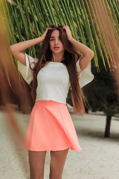 Foyer sélectif de belle fille posant sur la plage avec des feuilles de palmier — Photo de stock