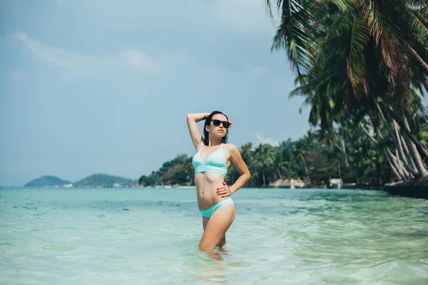 Beautiful girl in swimsuit at tropical sea resort — Stock Photo