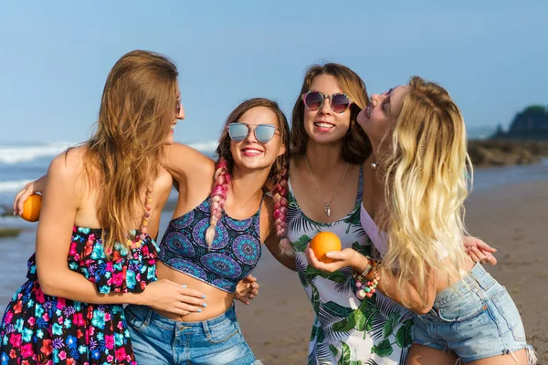 Grupo de mujeres jóvenes y felices abrazándose en la playa - foto de stock
