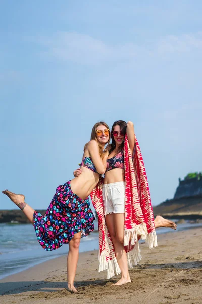 Glückliche junge Frauen im Bikini umarmen sich am Strand — Stockfoto
