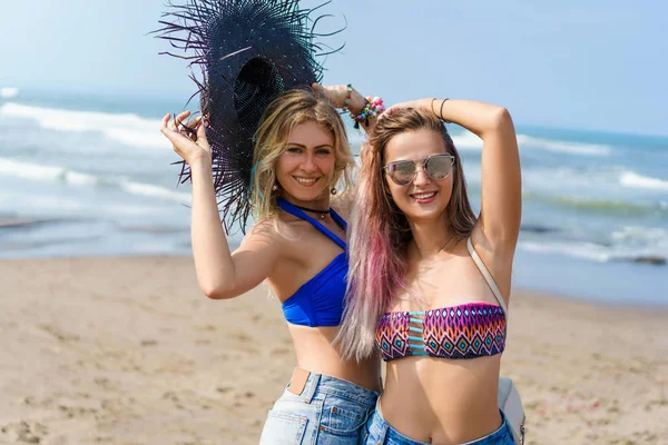 Щасливі молоді жінки в бікіні на узбережжі моря — стокове фото