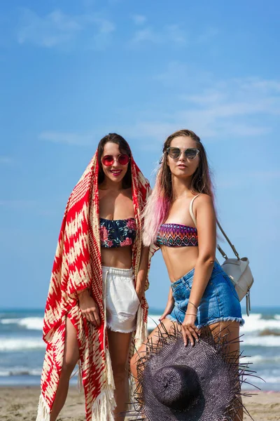 Jovens mulheres felizes em biquíni e óculos de sol na praia — Fotografia de Stock