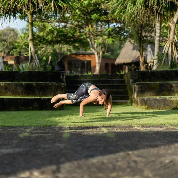 Belle femme heureuse pratiquant le yoga avec de belles plantes vertes sur fond, Bali, Indonésie — Photo de stock