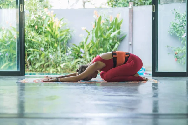 Vista laterale della giovane donna che pratica yoga nel bambino esteso (Utthita Balasana) posa — Foto stock