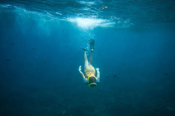 Underwater photo of woman in fins, diving mask and snorkel diving alone in ocean — Stock Photo