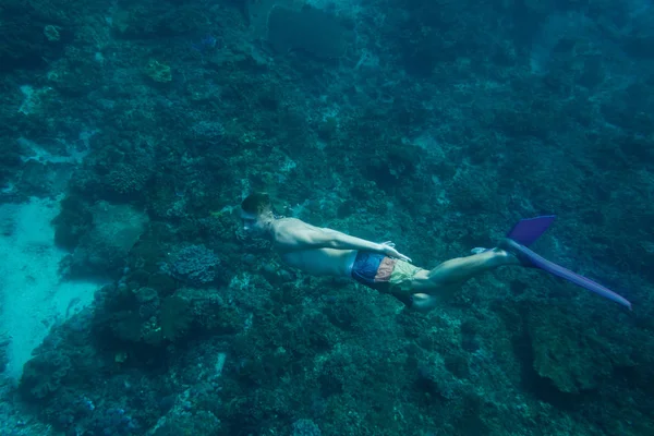 Seitenansicht eines jungen Mannes in Schwimmflossen, der allein im Ozean taucht — Stockfoto