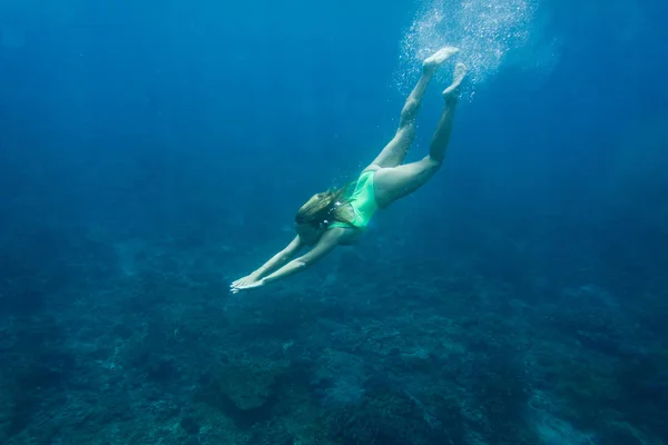 Foto subacquea di giovane donna in costume da bagno immersioni in mare da solo — Foto stock