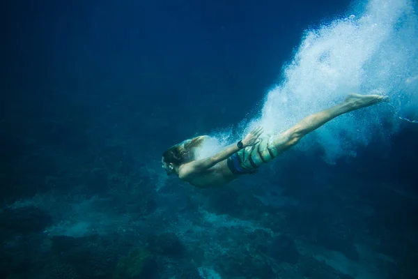 Подводное фото молодого человека, ныряющего в океан в одиночку — стоковое фото
