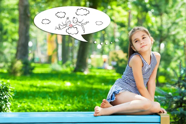 Menina sonhando sentado em um banco de parque — Fotografia de Stock