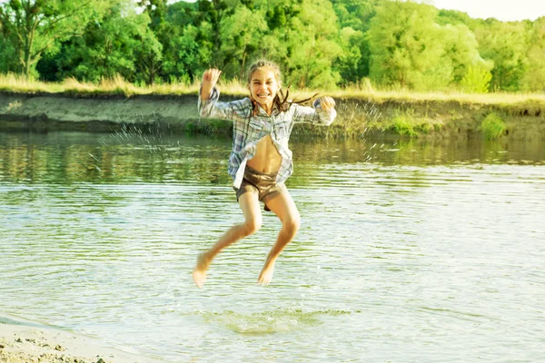 Счастливый ребенок брызгает водой — стоковое фото