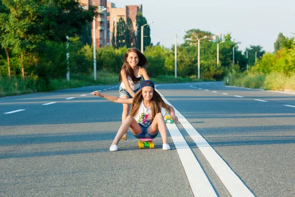 Mladé dívky s penny board mimo město — Stock fotografie