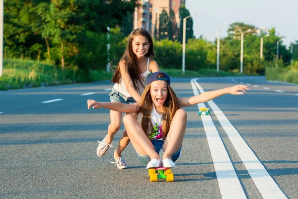 Mladé dívky s penny board mimo město — Stock fotografie