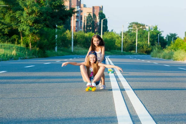 A young girls with penny board outside the city — Stock Photo, Image