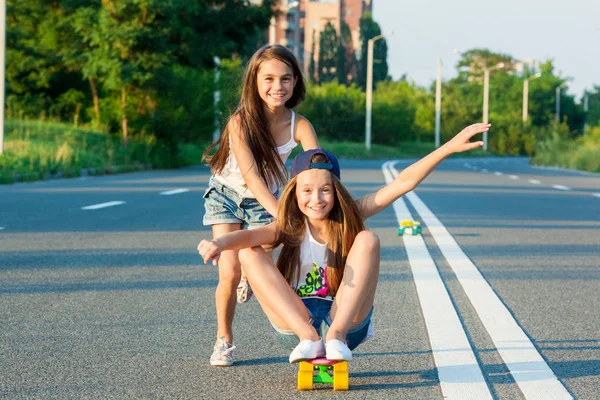 Mladé dívky s penny board mimo město — Stock fotografie