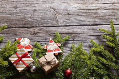 Noel kurabiyeleri, hediyeler ve köknar dalları arka planda gri ahşap vintage tahtalar