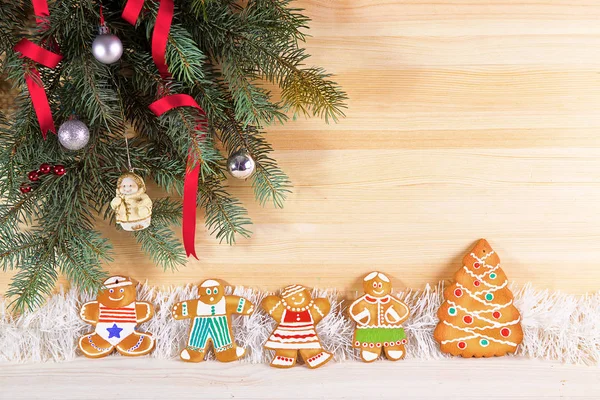 Auf Hellem Holzgrund Mit Tannenzweigen Stehen Holzständer Mit Weihnachtlichen Lebkuchen — Stockfoto