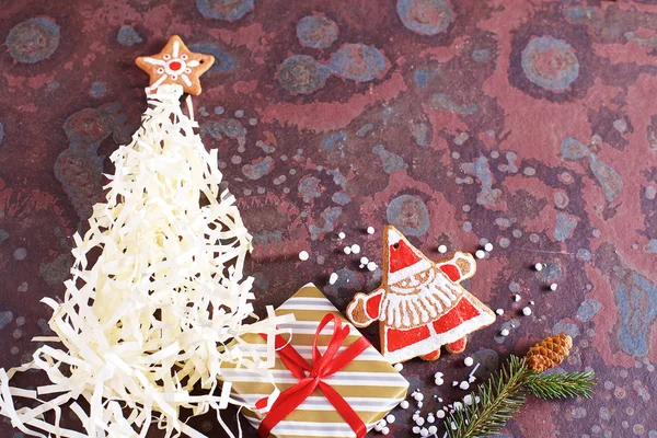 Homemade Christmas cookies, gifts and various decorations on a brown slate table. Festive christmas card