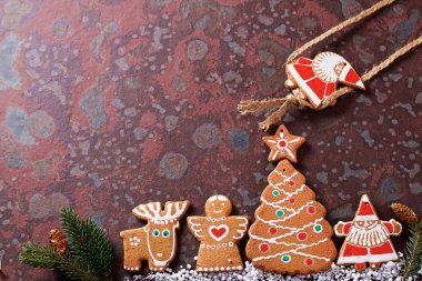 Ev yapımı Noel kurabiyeleri, hediyeler, ladin dalları, kahverengi bir kayrak masada çeşitli süslemeler. Festival noel kartı kompozisyonu