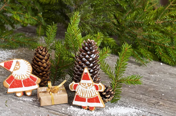 Christmas gingerbread cookies, gifts and fir branches on a background of gray wooden vintage boards