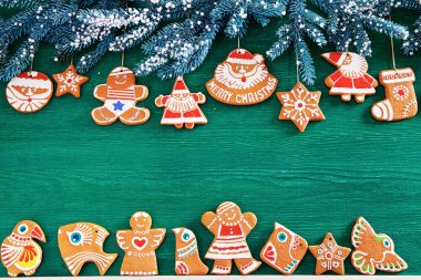 ladin dalları, Noel zencefilli kurabiye ve yeşil ahşap arka plan üzerinde süslemeleri. kartpostallar için