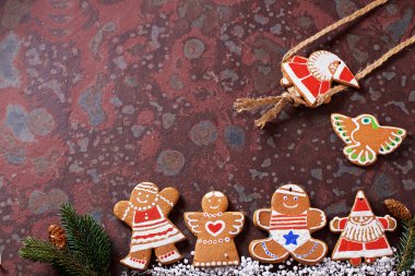 Ev yapımı Noel kurabiyeleri, hediyeler, ladin dalları, kahverengi bir kayrak masada çeşitli süslemeler. Festival noel kartı kompozisyonu