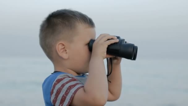 Маленький мальчик смотрит сквозь бинокль — стоковое видео
