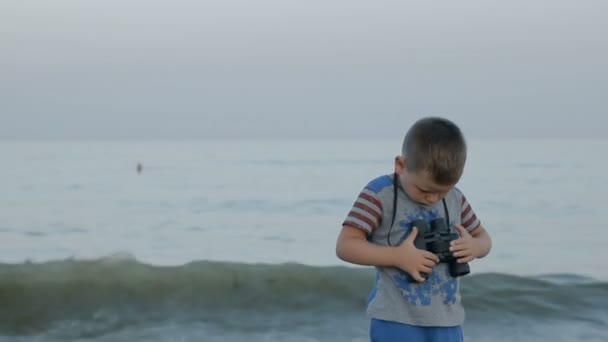 Junge im amerikanischen T-Shirt blickt durch Fernglas — Stockvideo