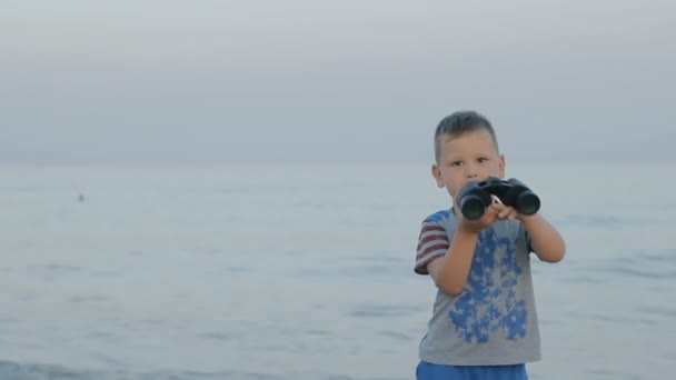 Petit garçon caucasien regarde à travers les jumelles — Video