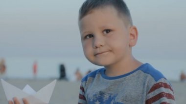 Kağıt gemi el ve yukarı çocuk tutar