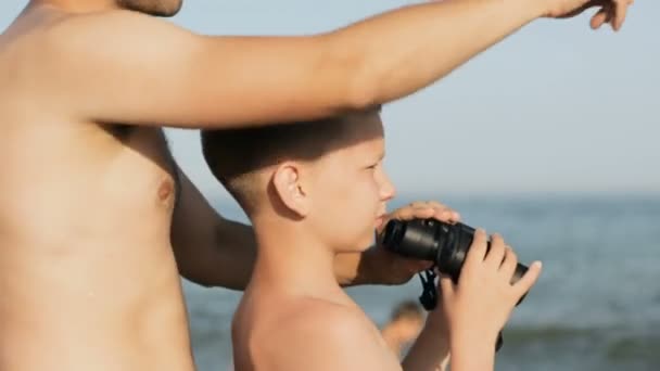 Niño y hombre salvavidas mirar a través de los prismáticos — Vídeos de Stock