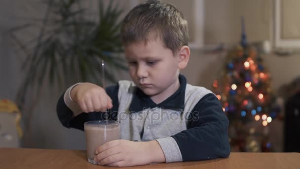 Junge rührt mit einem Löffel einen Milchshake an — Stockvideo