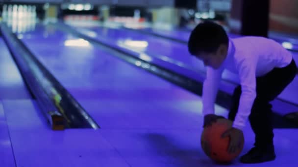 Pequeño niño tratar de jugar un juego de bolos — Vídeo de stock