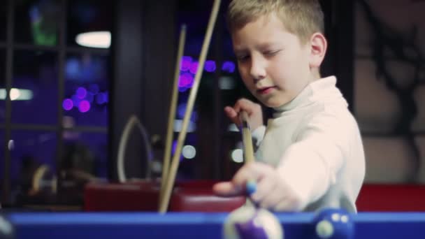 Billar americano. Chico jugando al billar. Niño preparándose para golpear la pelota — Vídeo de stock