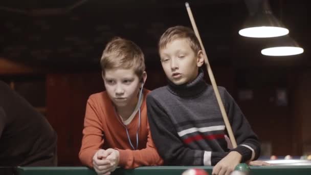 Un chico preparándose para jugar al billar mientras otro escucha música — Vídeo de stock