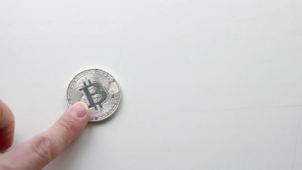 Τα χέρια δείχνουν χρυσό και ασήμι Bitcoins, σημάδι του Internet χρήματα σε λευκό φόντο — Αρχείο Βίντεο