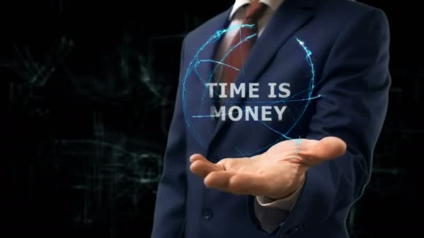 Επιχειρηματίας δείχνει έννοια ολόγραμμα χρόνο είναι χρήματα στο χέρι του — Αρχείο Βίντεο