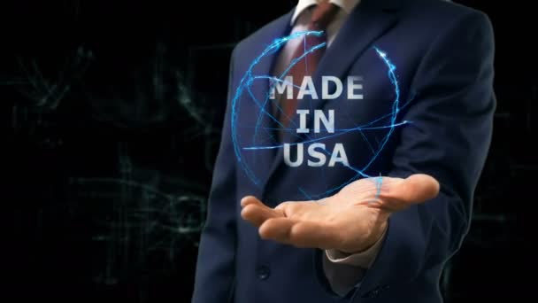 Бизнесмен показывает концептуальную голограмму Made in USA на руке — стоковое видео