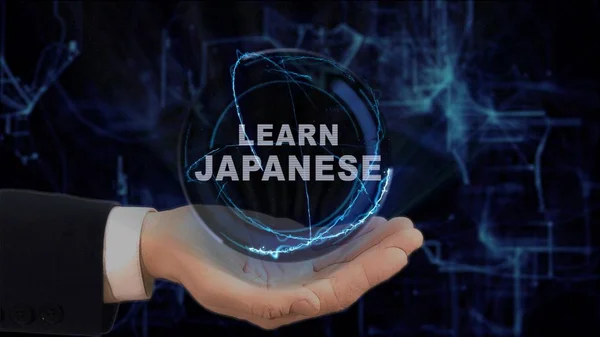 Painted hand shows concept hologram Learn Japanese on his hand