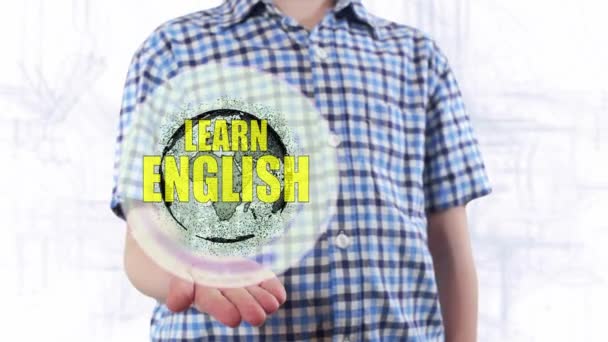 Young man shows a hologram of the planet Earth and text Learn English — Stock Video