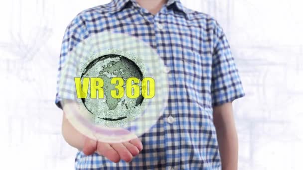 Young man shows a hologram of the planet Earth and text VR 360 — Stock Video