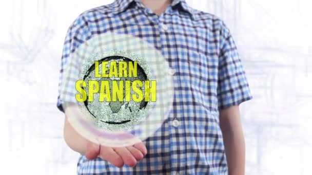 A fiatalember azt mutatja, hogy egy hologram, a Föld bolygó és a szöveg Learn spanyol — Stock videók