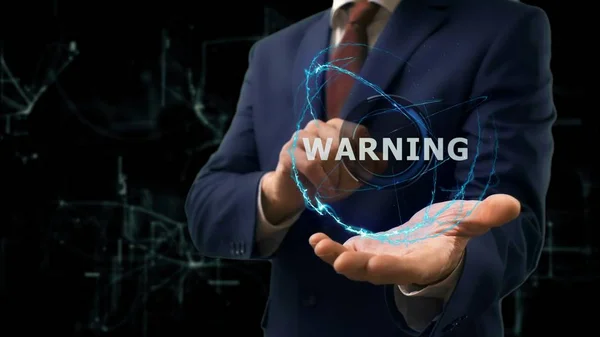 Empresario muestra concepto holograma Advertencia en su mano — Foto de Stock