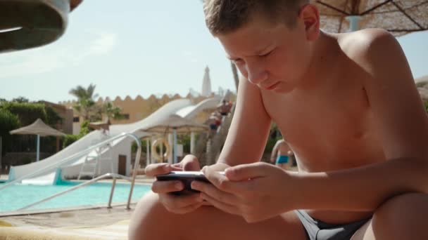 Tonåringen sitter nära poolen — Stockvideo